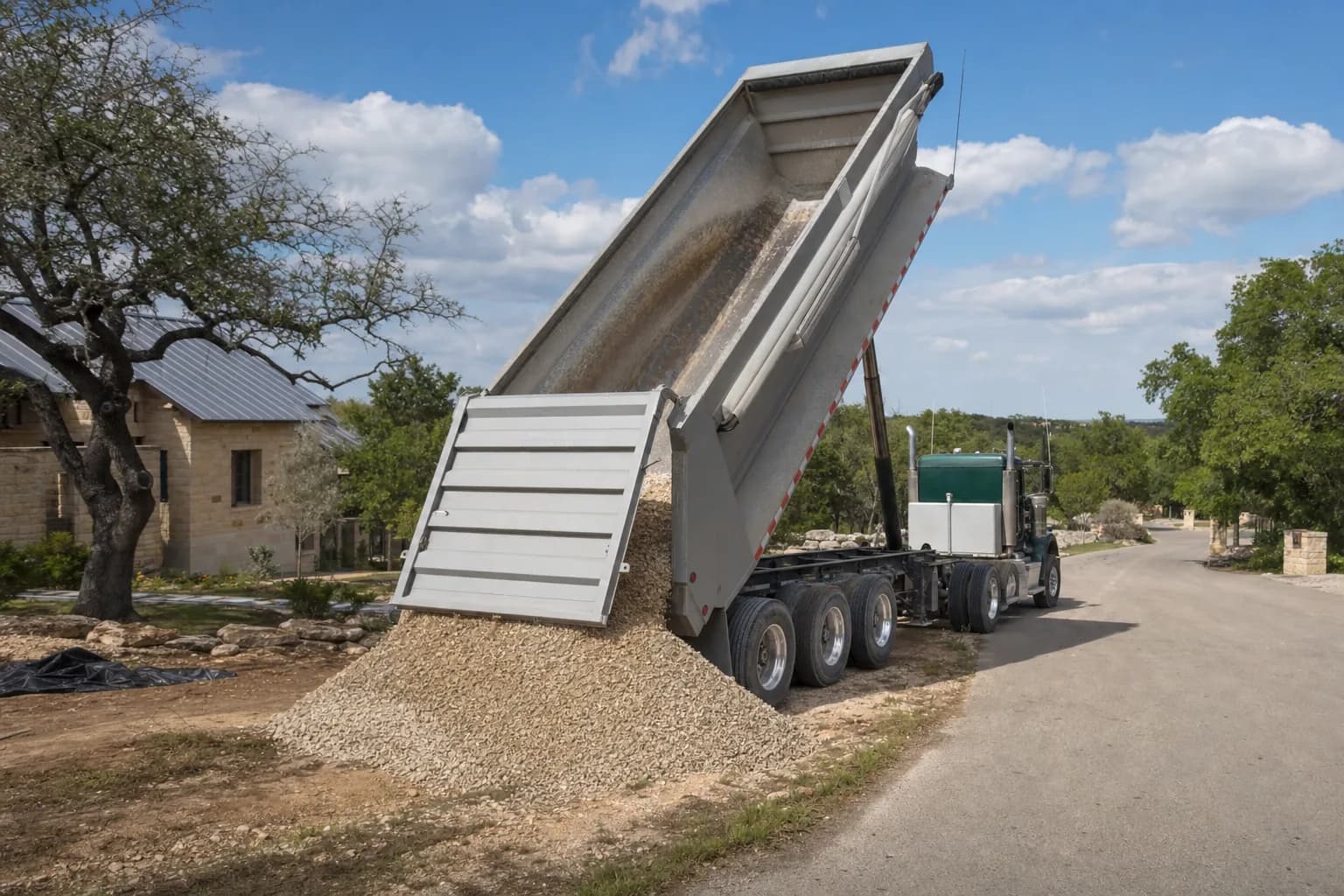 Dump truck delivering gravel to a residential property